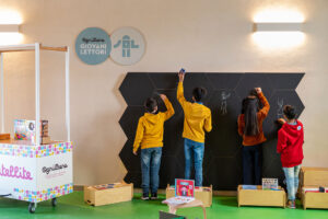Bambini disegnano su lavagna in biblioteca