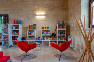 Interno biblioteca con sedie rosse e librerie